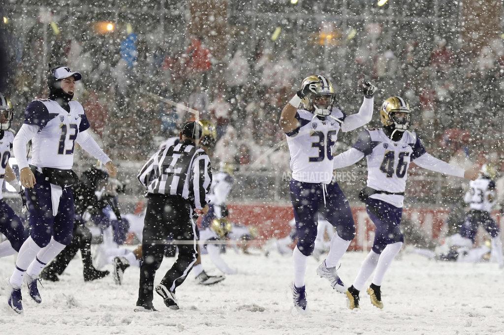 Ted S. Warren Washington players celebrate as they run onto the field after Washington defeated Washington State 28-15 in an NCAA college football game Friday, Nov. 23, 2018, in Pullman, Wash. (AP Photo/Ted S. Warren)