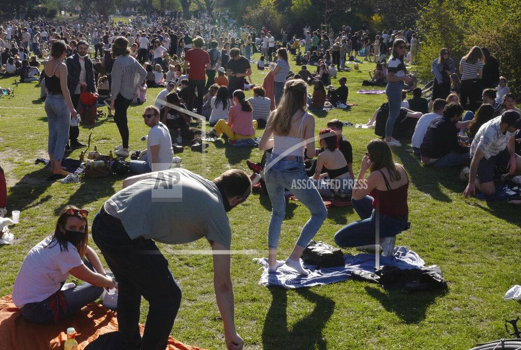 Michel Spingler People sit on the grass in the Vauban park in Lille, northern France, Tuesday, March 30, 2021. The number of patients in intensive care in France on Monday surpassed the worst point of the country's last coronavirus surge in the autumn of 2020, another indicator of how a renewed crush of infections is bearing down on French hospitals. (AP Photo/Michel Spingler)