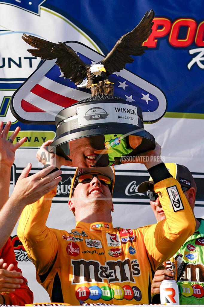 Matt Slocum Kyle Busch raises the trophy after winning a NASCAR Cup Series auto race at Pocono Raceway, Sunday, June 27, 2021, in Long Pond, Pa. (AP Photo/Matt Slocum)