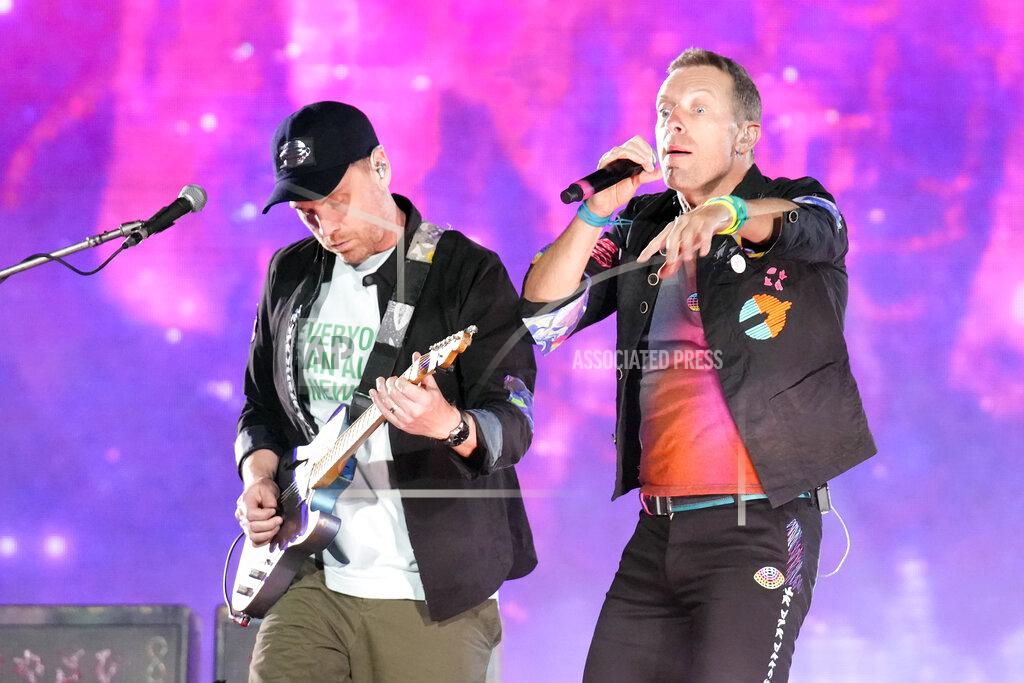 Rick Scuteri Jonny Buckland, left, and Chris Martin of Coldplay perform during the band's Music of the Spheres world tour on Thursday, May 12, 2022, at State Farm Stadium in Glendale, Ariz. (Photo by Rick Scuteri/Invision/AP)