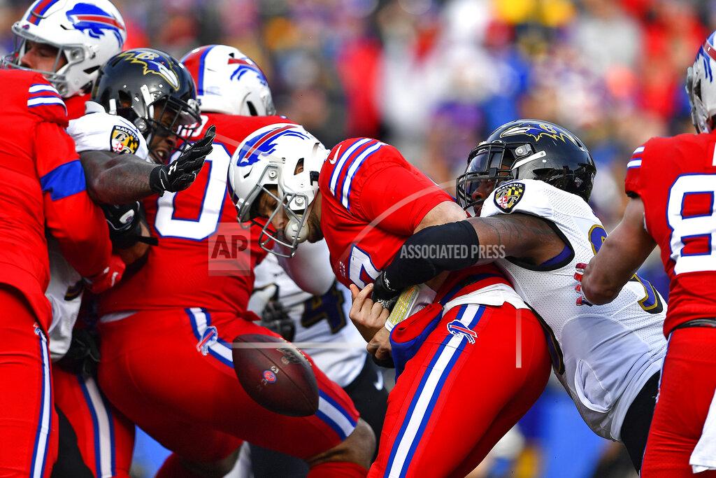 Buffalo Bills quarterback Josh Allen, center, has the ball knocked loose as he is hit by Baltimore Ravens outside linebacker Matt Judon (99), right, during the first half of an NFL football game in Orchard Park, N.Y., Sunday, Dec. 8, 2019. The fumble was recovered by Ravens defensive end Jihad Ward. (AP Photo/Adrian Kraus)