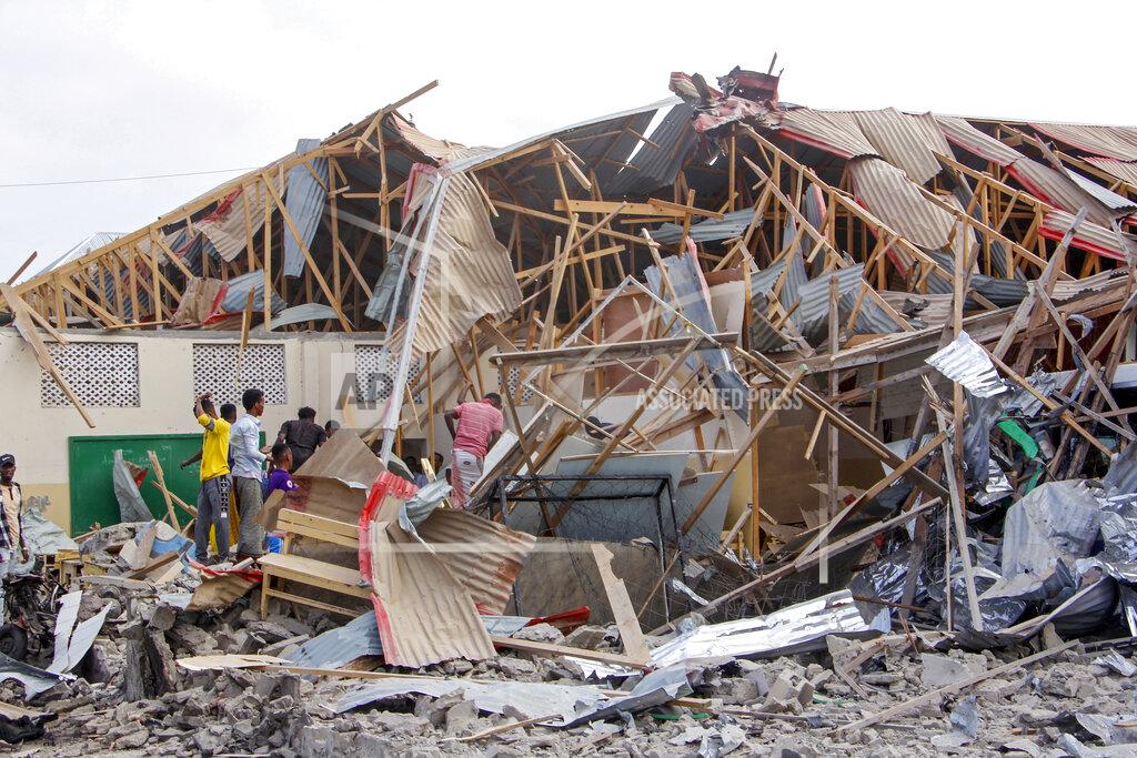 Farah Abdi Warsameh People search for bodies at the scene of a blast in Mogadishu, Somalia Thursday, Nov. 25, 2021. Witnesses say a large explosion has occurred in a busy part of Somalia's capital during the morning rush hour. (AP Photo/Farah Abdi Warsameh)