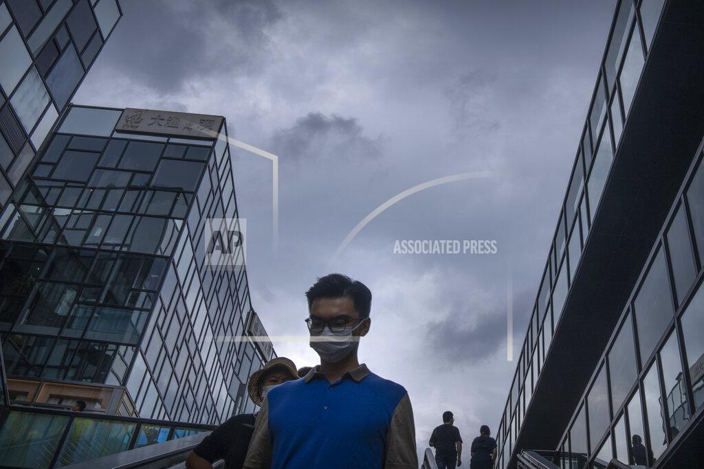 Mark Schiefelbein People wearing face masks to prevent the spread of COVID-19 walk at a shopping mall in Beijing, Saturday, July 17, 2021. A senior Chinese health official says China cannot accept the World Health Organization's plan for the second phase of a study into the origins of COVID-19. (AP Photo/Mark Schiefelbein)
