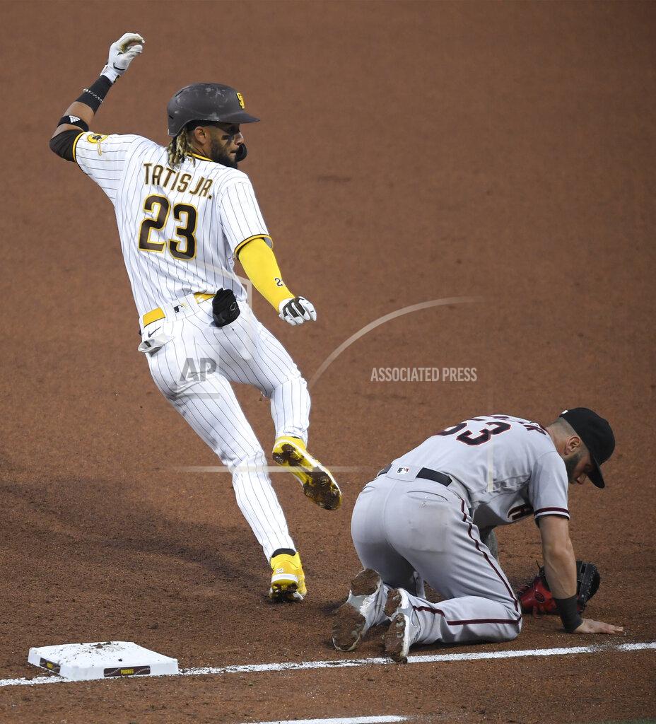 Denis Poroy San Diego Padres' Fernando Tatis Jr. runs past Arizona Diamondbacks first baseman Christian Walker during the fourth inning of a baseball game Saturday, April 3, 2021, in San Diego. Walker was hit by the ball. Tatis advanced to second base. (AP Photo/Denis Poroy)