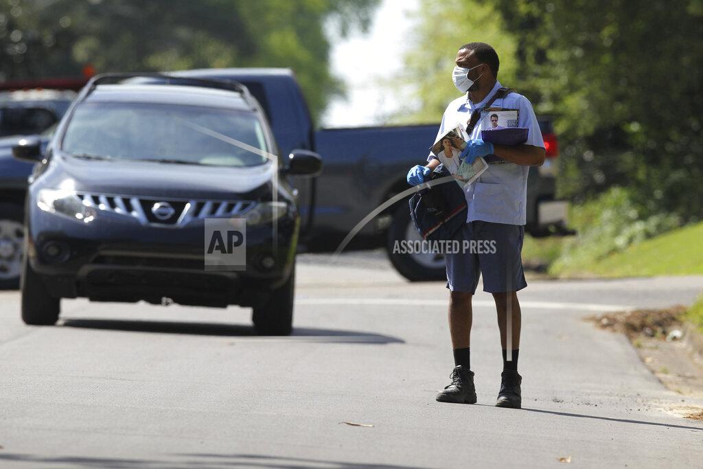 Thomas Wells In this Monday, April 6, 2020 photo, U.S. postal carrier Hakeem Watson wears both gloves and a mask as he delivers the mail to homes along Magnolia Street in Tupelo, Miss. (Thomas Wells/The Northeast Mississippi Daily Journal via AP)