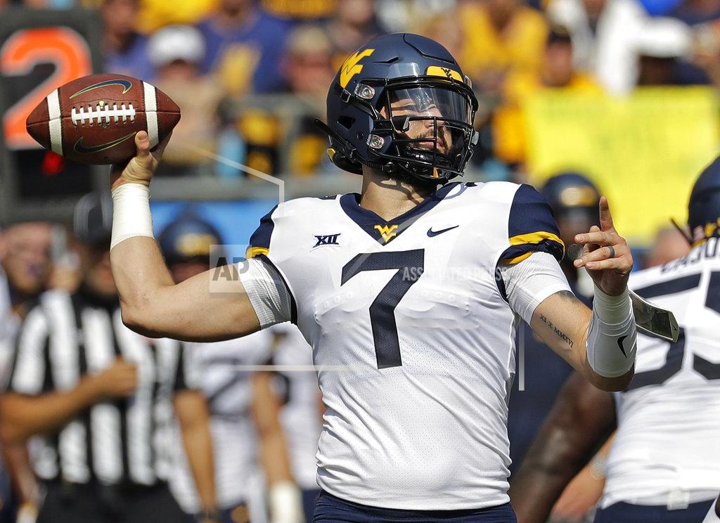 Chuck Burton FILE - In this Saturday, Sept. 1, 2018 file photo, West Virginia's Will Grier (7) looks to pass against Tennessee in the first half of an NCAA college football game in Charlotte, N.C. Grier injured his hand in during the play and left the game. Grier says he won't use a season-ending injury he suffered last season against Texas as additional motivation when No. 12 West Virginia plays the 15th-ranked Longhorns on Saturday, Nov. 3, 2018 in Austin, Texas. (AP Photo/Chuck Burton, File)