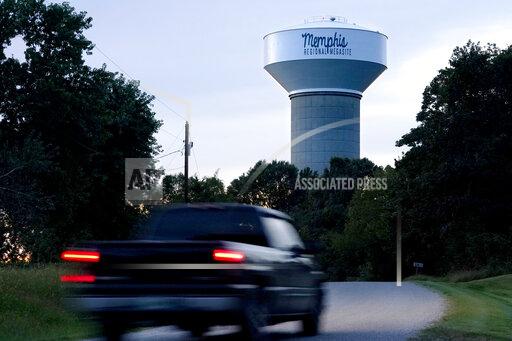 A truck drives down a rural road near a water tower marking the location of the Memphis Regional Megasite on Sept. 24, 2021, in Stanton, Tenn. Ford Motor Co. and SK Innovation of South Korea plan to build three new electric-vehicle battery factories and an auto assembly plant by 2025 in Tennessee and Kentucky. The industrial site in Stanton will be the location for a factory to produce electric F-Series pickups and a battery factory. (AP Photo/Mark Humphrey)