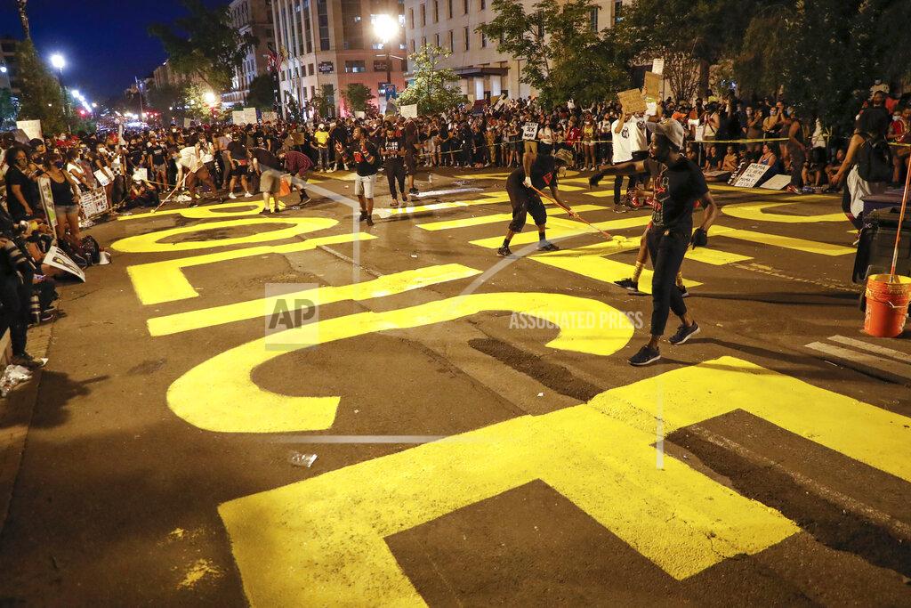 Jacquelyn Martin FILE - In this June 6, 2020, file photo, demonstrators paint the words "Defund the Police," as they protest near the White House in Washington, over the death of George Floyd, a black man who was in police custody in Minneapolis. The racial justice protests following the death of George Floyd spurred calls to “defund the police” in cities across the country, a priority for activists that has now become a central point in the presidential contest. (AP Photo/Jacquelyn Martin, File)