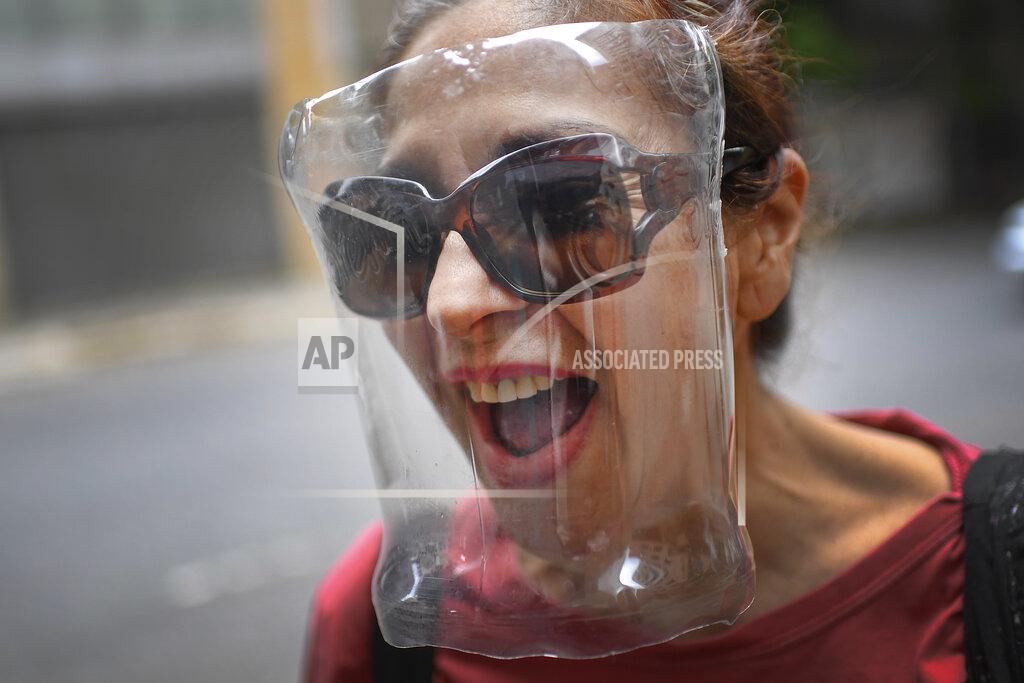 Matias Delacroix A woman wears a makeshift face shield made from a plastic bottle container as a precaution against the new coronavirus, in Caracas, Venezuela, Saturday, April 18, 2020. (AP Photo/Matias Delacroix)