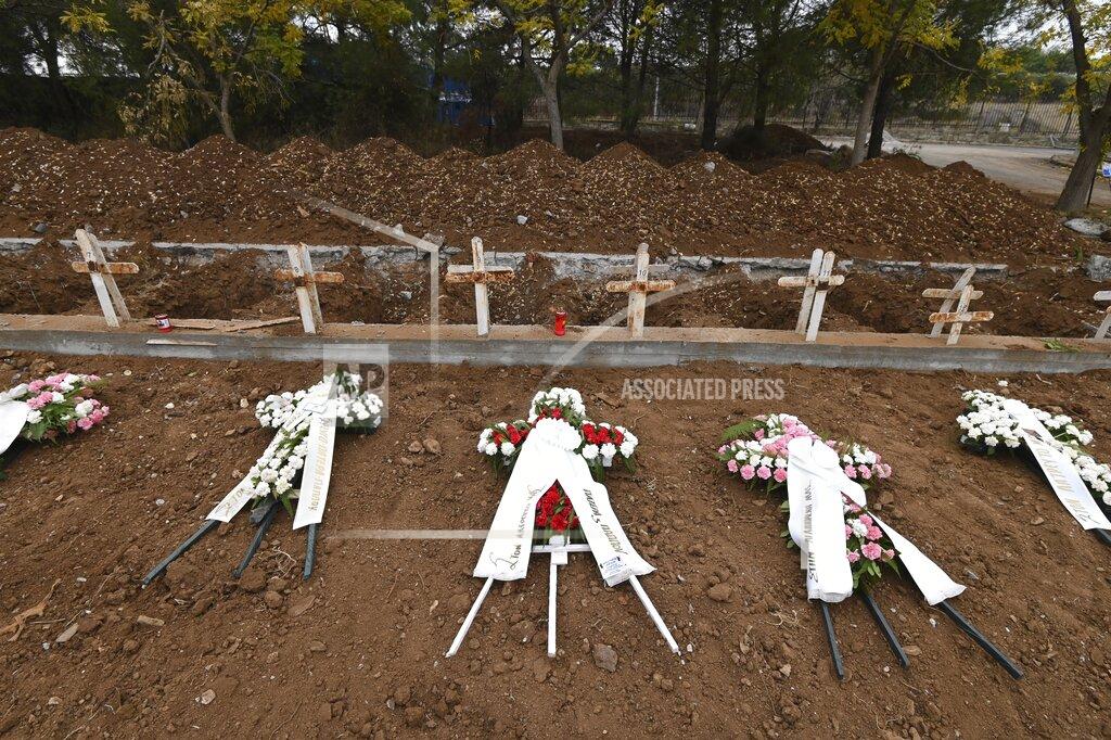 Giannis Papanikos Wreaths lie atop the new graves of recent fatalities of the coronavirus pandemic in the northern city of Thessaloniki, Greece, on Wednesday, Dec. 2, 2020. Greece has been battling a resurgence of the virus that has led to record numbers of daily deaths. A nationwide lockdown imposed in early November has been extended until Dec. 7. (AP Photo/Giannis Papanikos)