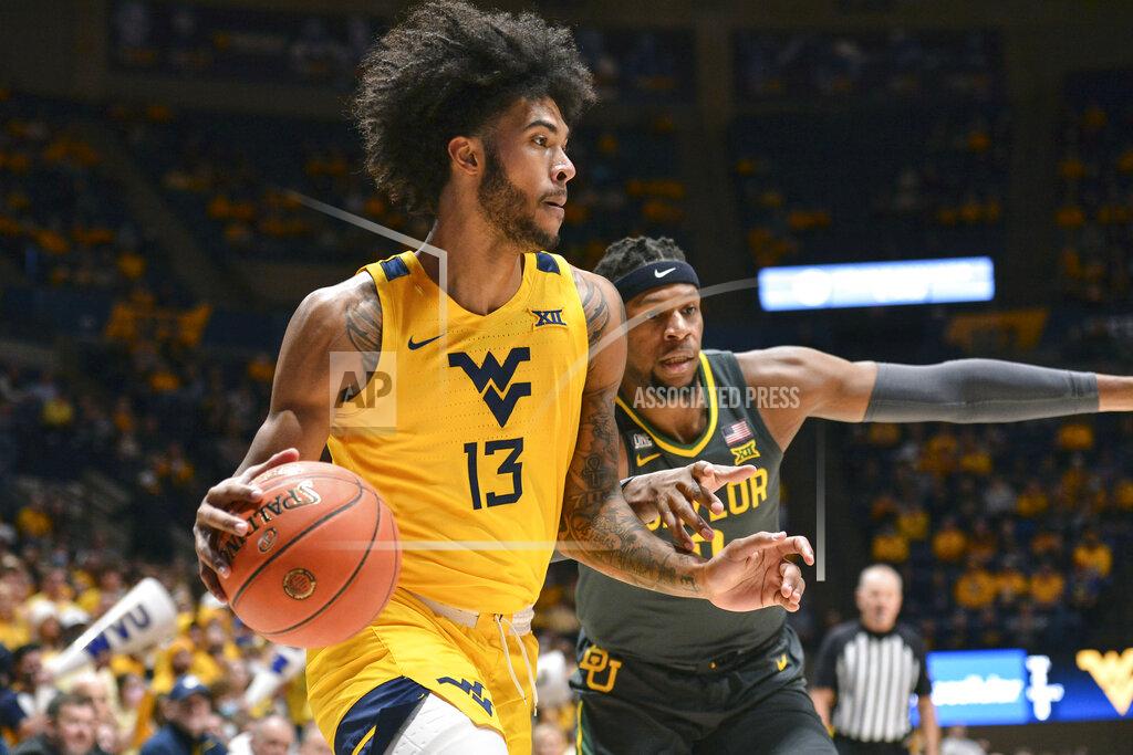 William Wotring West Virginia forward Isaiah Cottrell (13) drives to the basket while being guarded by Baylor forward Flo Thamba (0) during the first half of an NCAA college basketball game in Morgantown, W.Va., Tuesday, Jan. 18, 2022. (William Wotring)