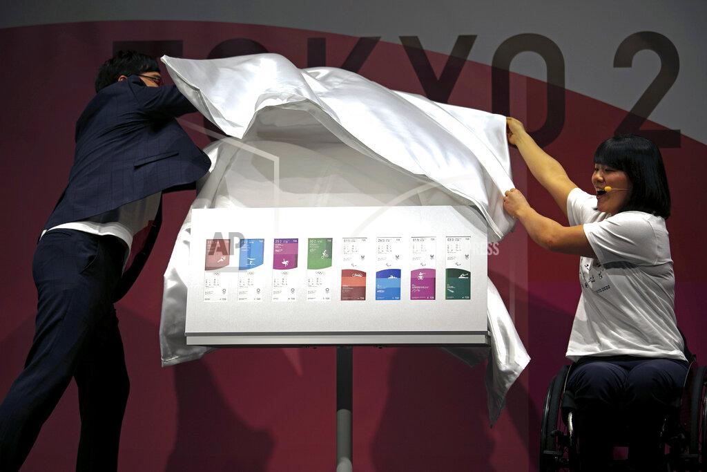 Paralympian Monika Seryu, right, and comedian Ryota Yamasato unveil tickets for the Tokyo 2020 Olympics and Paralympics Wednesday, Jan. 15, 2020, in Tokyo. (AP Photo/Jae C. Hong)