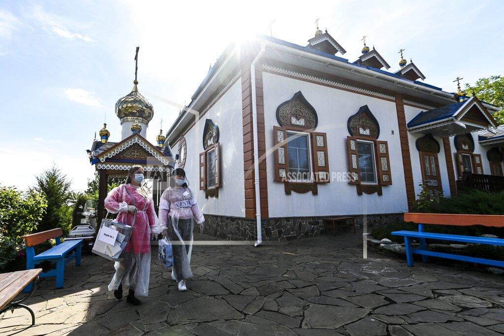 Uncredited Members of an election commission walk to help an elderly person to vote at its house in Starozolotovsky village, 160 km (100 miles) north of Rostov-on-Don during the Parliamentary elections , Russia, Saturday, Sept. 18, 2021. Sunday is the last of three days voting for a new parliament, but there seems to be no expectation that United Russia, the party devoted to President Vladimir Putin, will lose its dominance in the State Duma. (AP Photo)