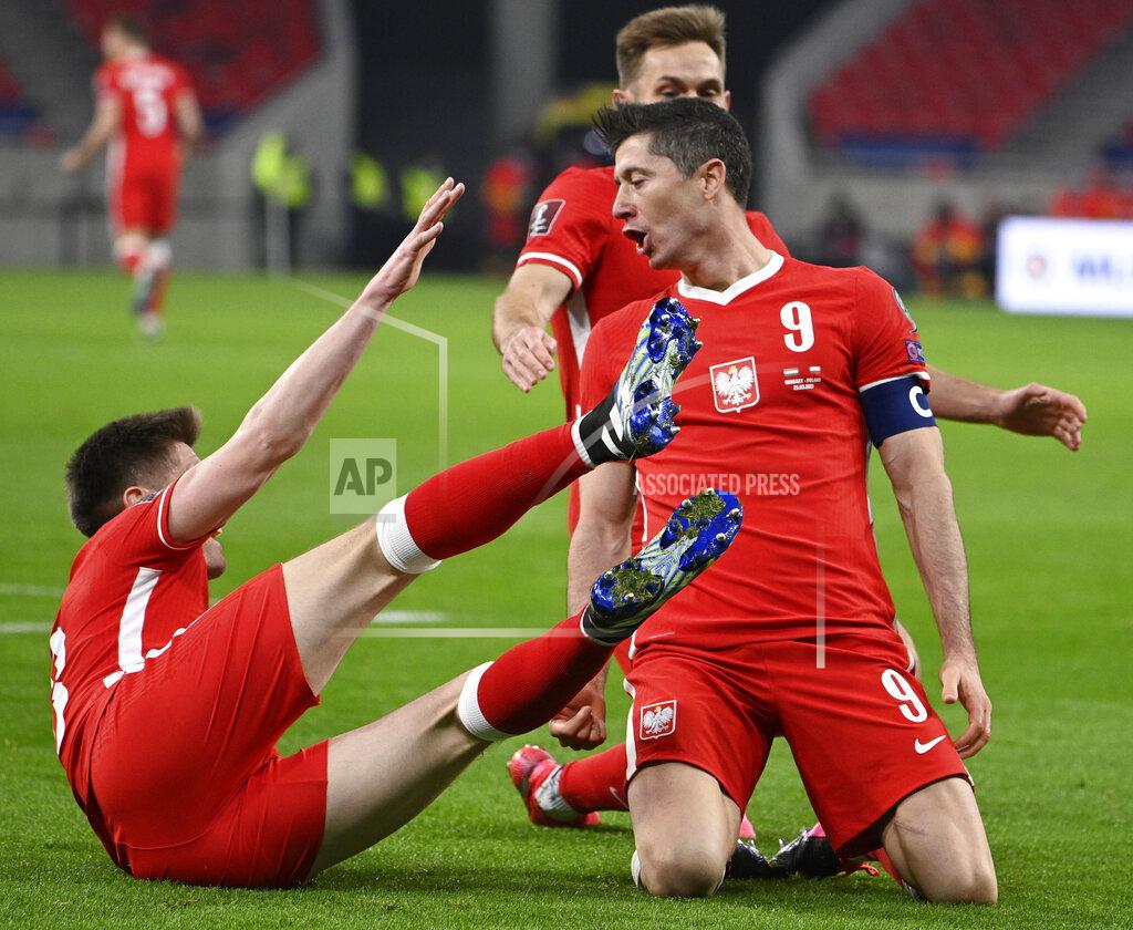 Zsolt Szigetvary Robert Lewandowski of Poland, right, celebrates after scoring the third goal against Hungary during the FIFA World Cup 2022 qualifying soccer match between Hungary and Poland in the Puskas Ferenc Arena in Budapest, Hungary, Thursday, March 25, 2021. (Zsolt Szigetvary/MTI via AP)