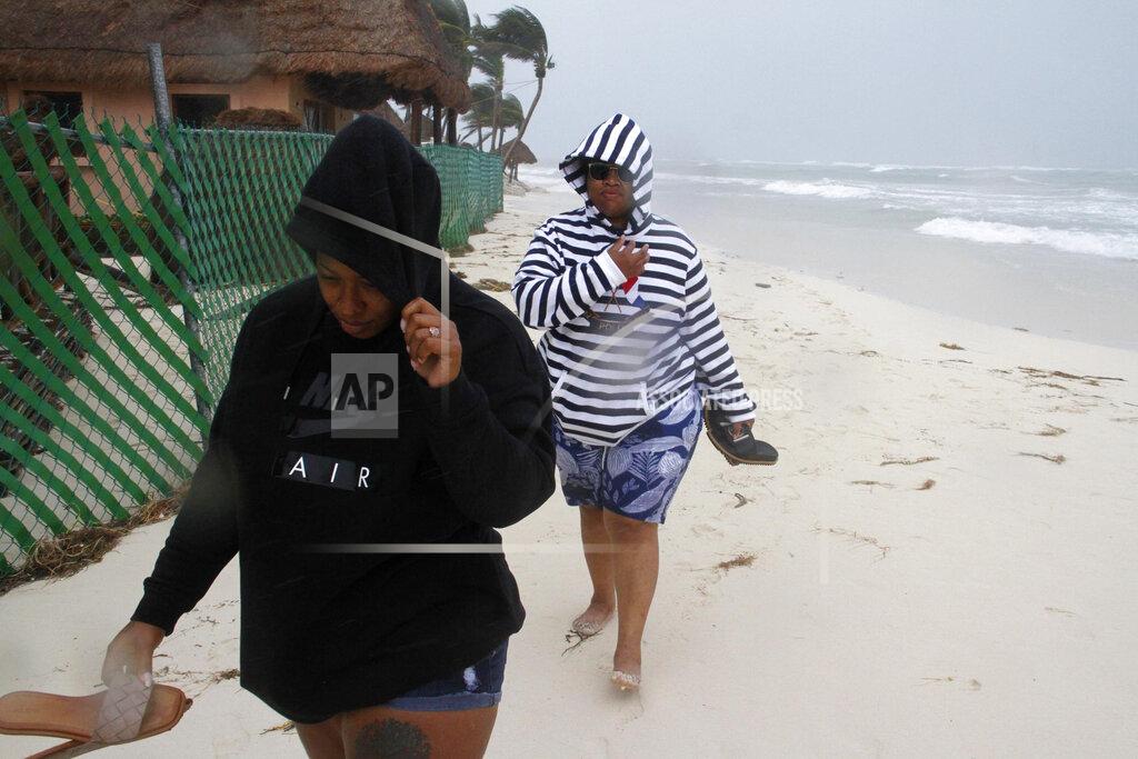 Tomas Stargardter Tourists walk on the beach as the tail end of Hurricane Zeta makes landfall in Playa del Carmen, Mexico, early Tuesday, Oct. 27, 2020. Zeta is leaving Mexico’s Yucatan Peninsula on a path that could hit New Orleans Wednesday night. (AP Photo/Tomas Stargardter)