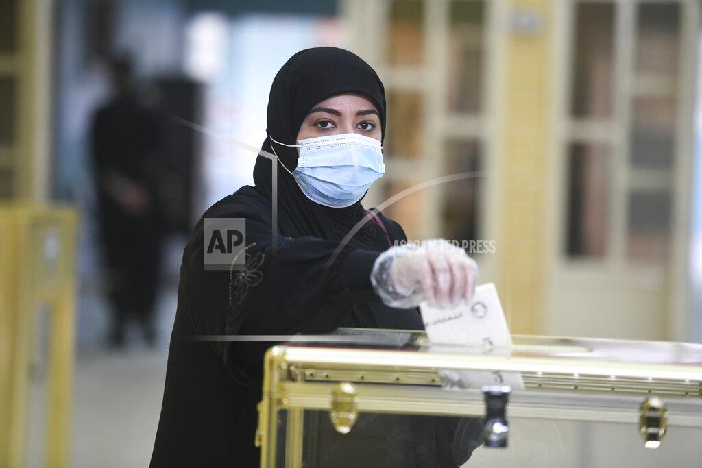 Jaber Abdulkhaleg A woman casts her vote for parliamentary elections in the town of Hawally, Kuwait, Saturday, Dec. 5, 2020. (AP Photo/Jaber Abdulkhaleg)