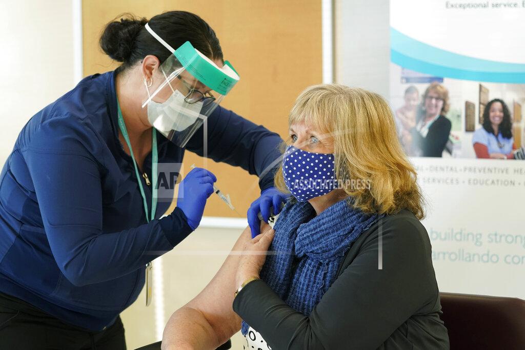 Ted S. Warren Trudi Inslee, right, the wife of Washington Gov. Jay Inslee, gets the first shot of the Moderna COVID-19 vaccine, Friday, Jan. 22, 2021, from Elizabeth Smalley, left, a medical assistant at a Sea Mar Community Health Center in Olympia, Wash. Gov. Inslee also received the first dose of the vaccine Friday. (AP Photo/Ted S. Warren)