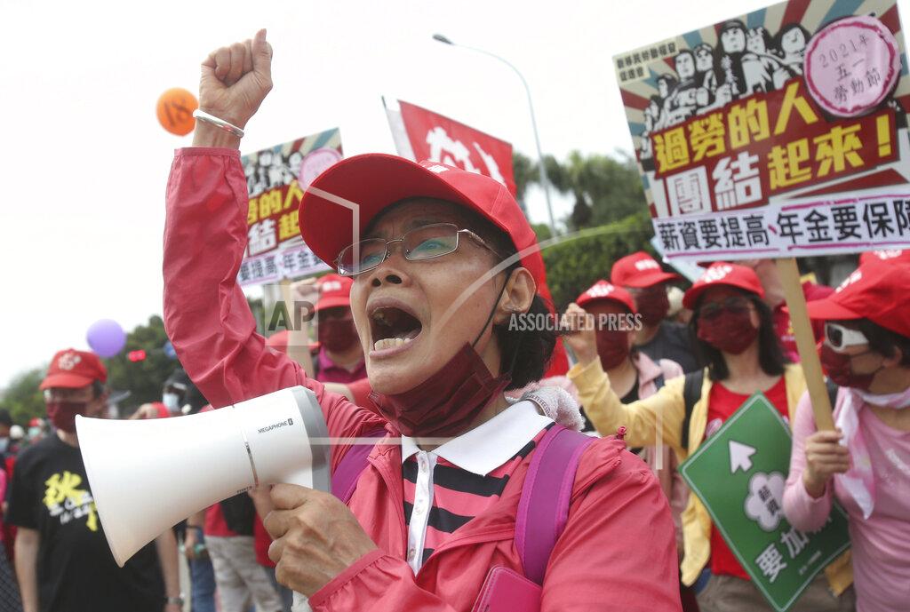 Chiang Ying-Ying Taiwanese workers shout and hold slogans during a May Day rally in Taipei, Taiwan, Saturday, May 1, 2021. Thousands of protesters from different labor groups protest on the street to ask for increasing salary and securing annuity. (AP Photo/Chiang Ying-ying)