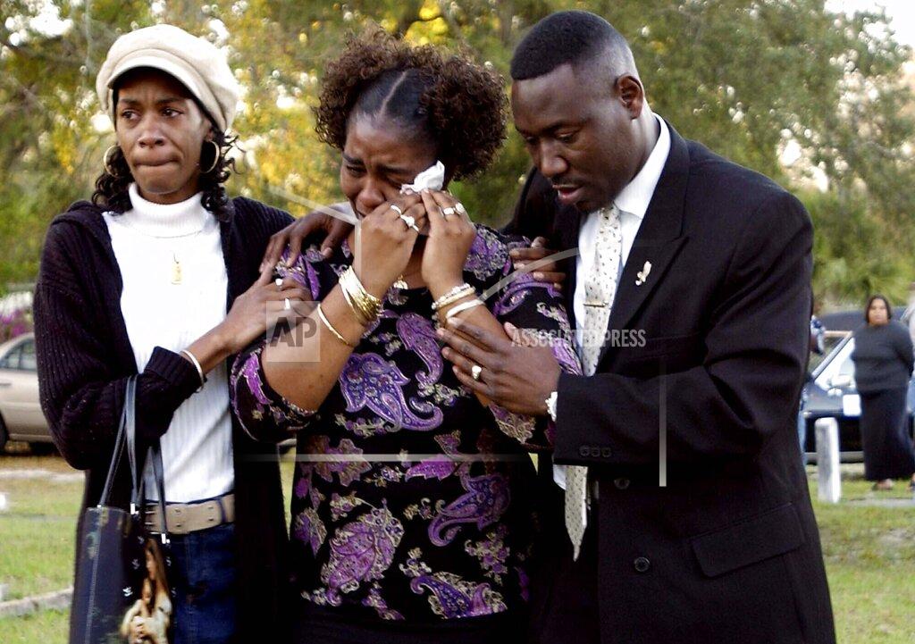 Mari Darr-Welch FILE - In this Tuesday, March 14, 2006 file photo, Gina Jones, center, mother of 14-year-old Martin Lee Anderson, is comforted by her sister, Debbie Williams, and attorney Benjamin Crump, after reburying her son in Panama City, Fla. Jones said Tuesday she wants justice now that a second autopsy showed that he did not die from a blood disorder as a medical examiner initially ruled. (AP Photo/Mari Darr-Welch)