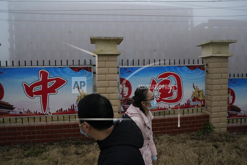 Ng Han Guan Journalists pass by the words "China" along a fence near the Wuhan Institute of Virology after a World Health Organization team arrived for a field visit in Wuhan in China's Hubei province on Wednesday, Feb. 3, 2021. The WHO team is investigating the origins of the coronavirus pandemic has visited two disease control centers in the province. (AP Photo/Ng Han Guan)