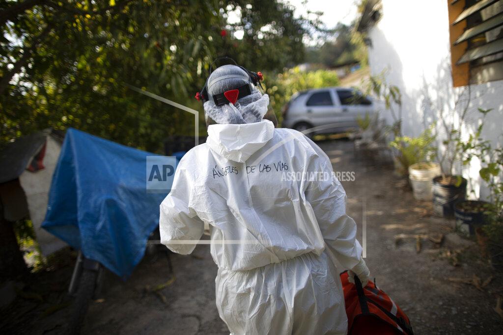 Ariana Cubillos Wearing a biosecurity suit, Dr. Debora Mejia, an Angels of the Road volunteer, walks out of a house after visiting two COVID-19 patients in Caracas, Venezuela, Wednesday, Feb. 3, 2021. Each day brings on average three to four calls, and the new coronavirus pandemic means that at least one of those is a request to take a patient with trouble breathing to a hospital. (AP Photo/Ariana Cubillos)