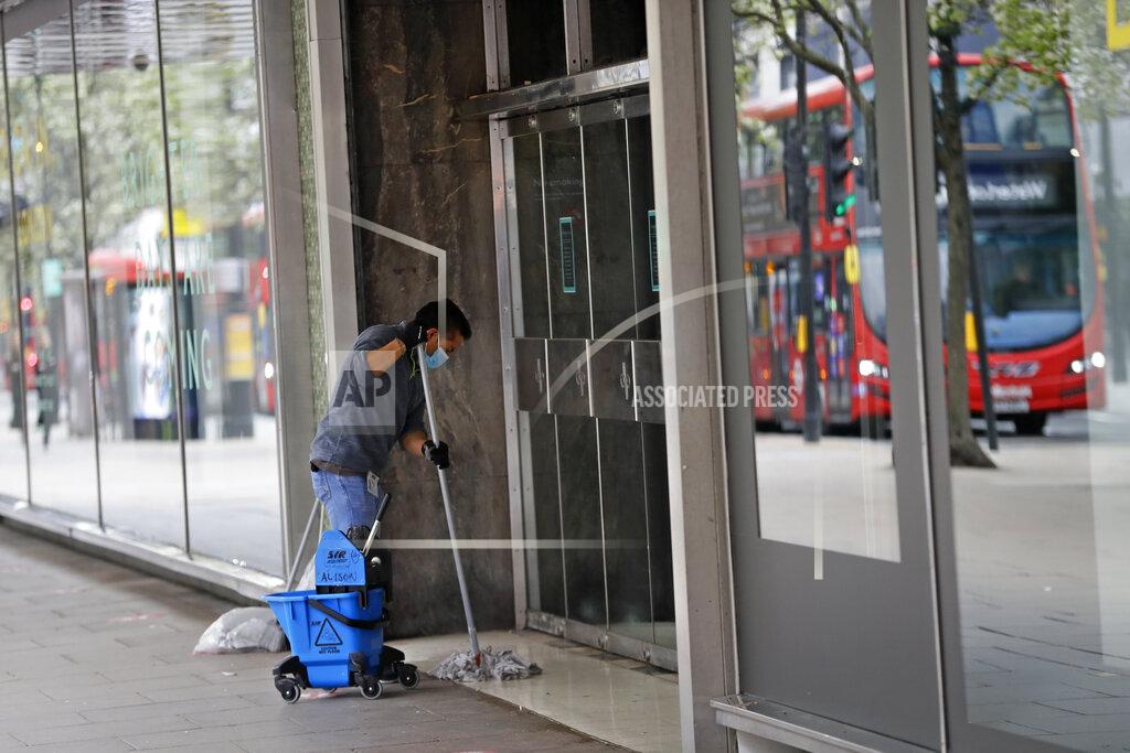 Kirsty Wigglesworth A worker mops a building entrance on Oxford Street in London, Monday, April 12, 2021. Millions of people in England will get their first chance in months for haircuts, casual shopping and restaurant meals on Monday, as the government takes the next step on its lockdown-lifting road map. (AP Photo/Kirsty Wigglesworth)
