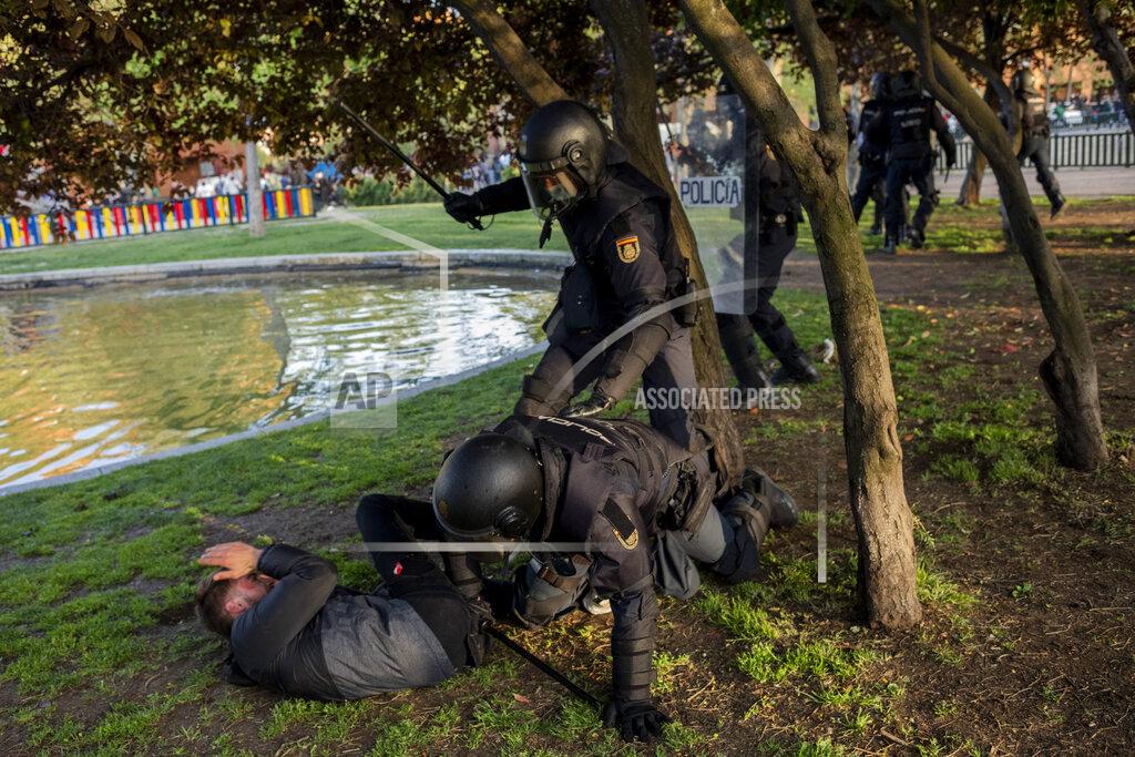 Bernat Armangue Spanish police detain a left-wing protester in Madrid's Vallecas neighborhood, Spain, Wednesday, April 7, 2021. Spanish police have used batons to keep protesters away from a campaign event of the far-right Vox party in Madrid. Scuffles started Wednesday when Santiago Abascal, the national leader of Vox, approached a crowd gathered to protest the party rally in Madrid's Vallecas neighborhood, a traditional left-wing bastion. Riot peace charged the bunches of protesters to keep them away from the party campaign event for upcoming regional elections. (AP Photo/Bernat Armangue)