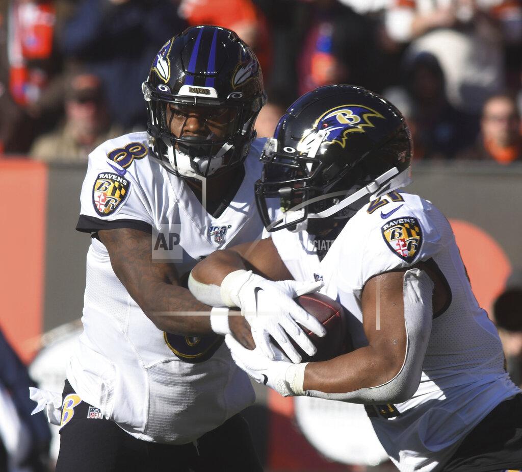 Baltimore Raven quarterback Lamar Jackson hands off to running back Mark Ingram during an NFL football game against the Cleveland Brown at FirstEnergy Stadium in Cleveland on Sunday, Dec. 22, 2019. (Warren Dillaway/The Star-Beacon via AP)