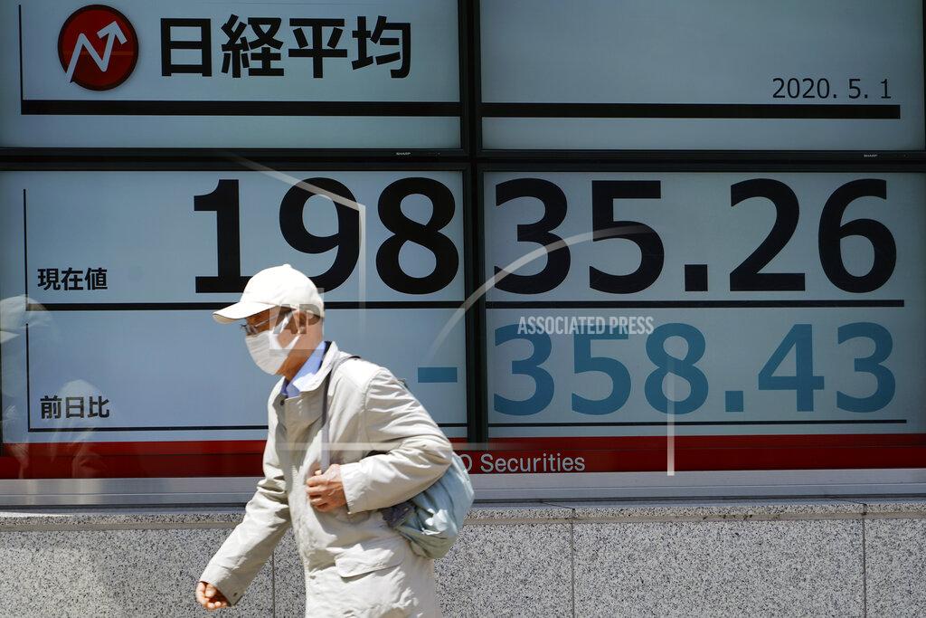Eugene Hoshiko A man walks past an electronic stock board showing Japan's Nikkei 225 index at a securities firm in Tokyo Friday, May 1, 2020. Shares have dropped in Asia after Wall Street ended its best month in 33 years with losses on fresh news of economic carnage from the coronavirus pandemic. (AP Photo/Eugene Hoshiko)
