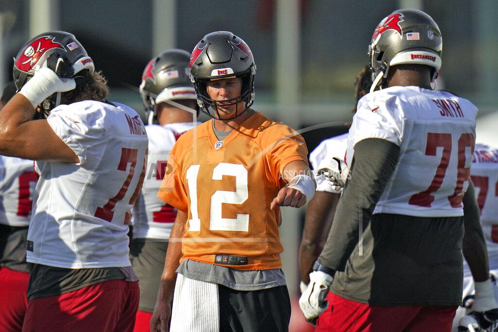 Chris O'meara Tampa Bay Buccaneers quarterback Tom Brady (12) fist bumps offensive tackle Donovan Smith (76) as they line up for a play during an NFL football practice Tuesday, July 27, 2021, in Tampa, Fla. (AP Photo/Chris O'Meara)