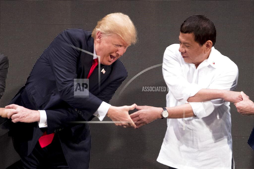 Andrew Harnik FILE - In this Nov. 13, 2017, file photo, U.S. President Donald Trump, left, reacts as he does the "ASEAN-way handshake" with Vietnamese Prime Minister Nguyen Xuan Phuc, not pictured, and Philippine President Rodrigo Duterte on stage during the opening ceremony at the ASEAN Summit at the Cultural Center of the Philippines, in Manila. Nation by nation, how is Election Day in the United States being watched, considered, assessed? The next U.S. president could reshape the country's relationship with President Rodrigo Duterte, who leads a key American treaty ally in Asia — but presents a dilemma. Duterte has been regarded by international watchdogs as a human rights calamity for his notorious anti-drug crackdown that has left thousands of mostly poor suspects dead. He has been accused of undermining one of Asia's most vibrant democracies — an American legacy. (AP Photo/Andrew Harnik, File)