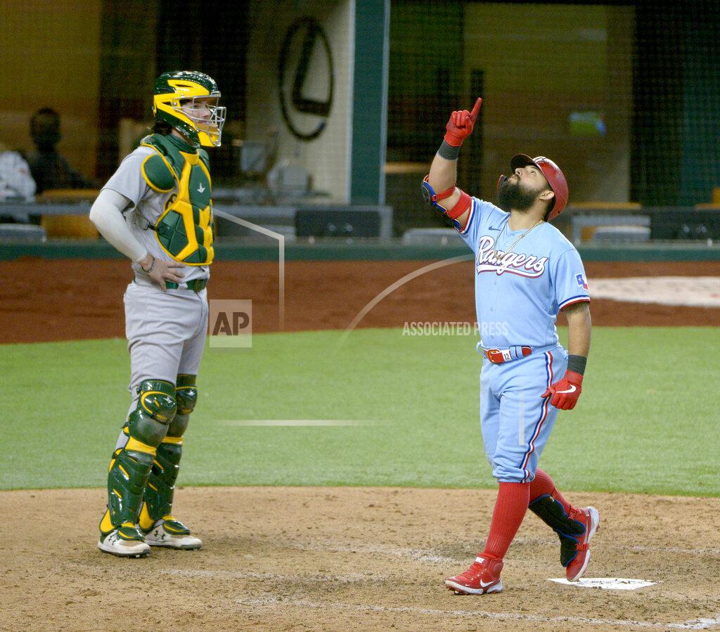 Matt Strasen Texas Rangers' Rougned Odor celebrates as he touches home plate after hitting a three-run home run in the sixth inning of a baseball game against the Oakland Athletics in Arlington, Texas, Sunday, Sept. 13, 2020. Athletics catcher Jonah Heim, left, looks on. (AP Photo/Matt Strasen)