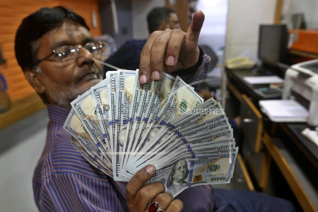 Fareed Khan A Pakistani money trader checks U.S. 100 dollar notes at a currency exchange office, in Karachi, Pakistan, Thursday, May 19, 2022. Pakistan’s currency has plummeted to an all-time record low in intraday trading against the U.S. dollar amid uncertainty about the success of crucial talks between the International Monetary Fund and the government of Prime Minister Shahbaz Sharif, which is considering massive new taxation to avoid a default. (AP Photo/Fareed Khan)