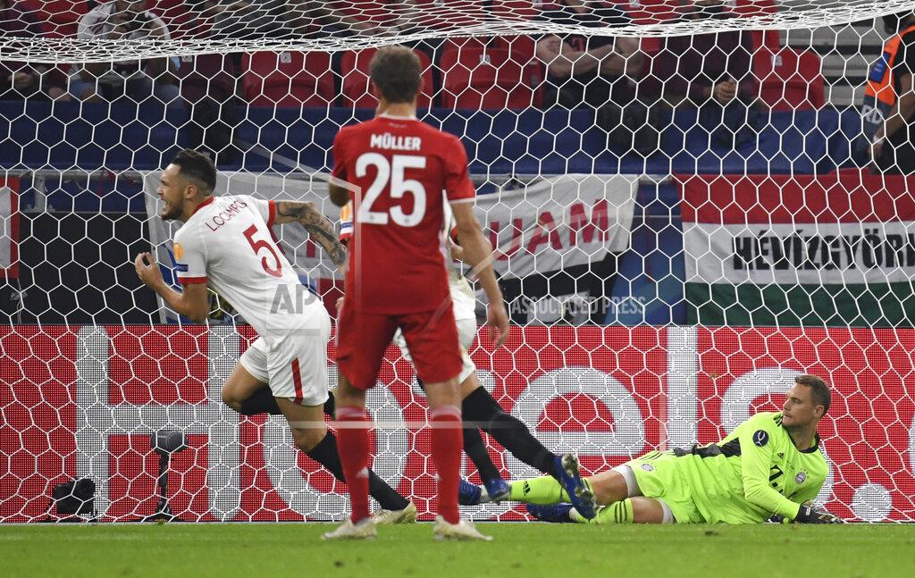 Tibor Ilyes Sevilla's Lucas Ocampos, left, celebrates after scoring during the UEFA Super Cup soccer match between Bayern Munich and Sevilla at the Puskas Arena in Budapest, Hungary, Thursday, Sept. 24, 2020. (Tibor Ilyes/Pool via AP)