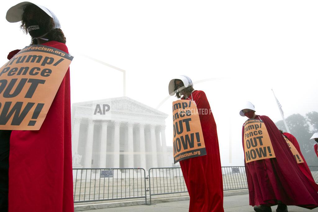 Jose Luis Magana Activists opposed to the confirmation of President Donald Trump's Supreme Court nominee, Judge Amy Coney Barrett, dressed as characters from "The Handmaid's Tale," protest at the Supreme Court on a foggy day, Thursday, Oct. 22, 2020, on Capitol Hill in Washington. (AP Photo/Jose Luis Magana)
