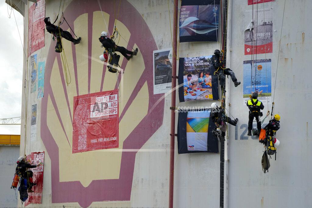 Peter Dejong FILE- In this Monday, Oct. 4, 2021, file photo, Dutch police, second right and fourth right, top, break up a demonstration of Greenpeace climate activists who lowered themselves from a fuel storage tank during a protest at a Shell refinery in Rotterdam, Netherlands. The Netherlands' biggest pension fund announced Tuesday Oct. 26, 2021, that it will stop investing in companies that produce fossil fuels, saying the move that has long been demanded by members of the fund was prompted by recent climate reports by the United Nations and International Energy Agency. (AP Photo/Peter Dejong, file)