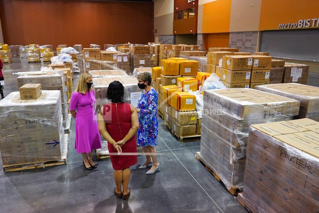 Ross D. Franklin Phoenix Mayor Kate Gallego, left, Phoenix Vice Mayor Betty Guardado, middle, and Dr. Lily DeBlieux, right, Superintendent of the Pendergast Elementary School District, stands near pallets totaling more than one million pieces of PPE to help Phoenix schools reopen for the 2020-2021 school year in a Phoenix Convention Center hall as the City of Phoenix begins to ship the supplies out to schools Tuesday, Sept. 8, 2020, in Phoenix. (AP Photo/Ross D. Franklin)