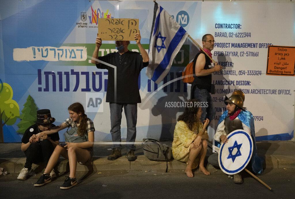 Ariel Schalit Israeli protesters hold signs during a demonstration against Israeli Prime Minister Benjamin Netanyahu outside his official residence in Jerusalem, Saturday, June 12, 2021. If all goes according to plan, Israel will swear in a new government on Sunday, ending Prime Minister Benjamin Netanyahu's record 12-year rule and a political crisis that inflicted four elections on the country in less than two years. (AP Photo/Ariel Schalit)