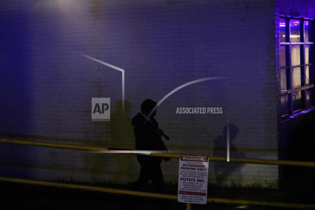 Brynn Anderson A official walks the perimeter of Gold Spa massage parlor after a shooting on Tuesday, March 16, 2021, in Atlanta. Shootings at two massage parlors in Atlanta and one in the suburbs left multiple people dead, many of them women of Asian descent, authorities said. A 21-year-old man suspected in the shootings was taken into custody in southwest Georgia hours later after a manhunt, police said. (AP Photo/Brynn Anderson)