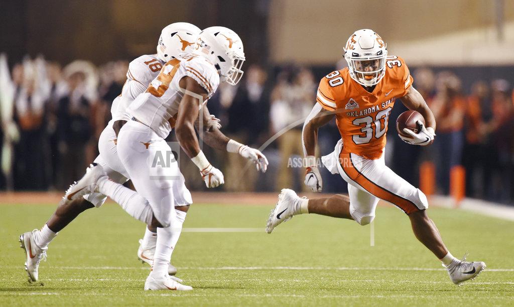 Brody Schmidt Oklahoma State running back Chuba Hubbard, right, runs down field under pressure from Texas defensive backs Davante Davis, left back, and Josh Thompson in the first half of an NCAA college football game in Stillwater, Okla., Saturday, Oct. 27, 2018. (AP Photo/Brody Schmidt)