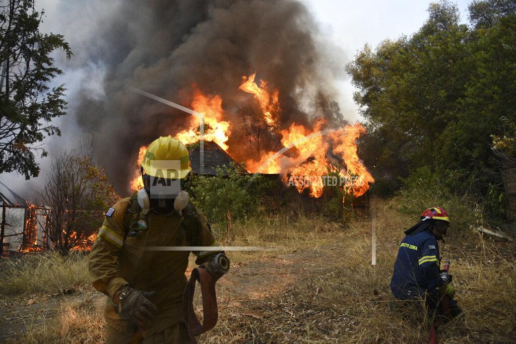 Andreas Alexopoulos Firefighters operate during a wildfire near Lampiri village, west of Patras, Greece, Saturday, Jul. 31, 2021. The fire, which started high up on a mountain slope, has moved dangerously close to seaside towns and the Fire Service has send a boat to help in a possible evacuation of people. (AP Photo/Andreas Alexopoulos)