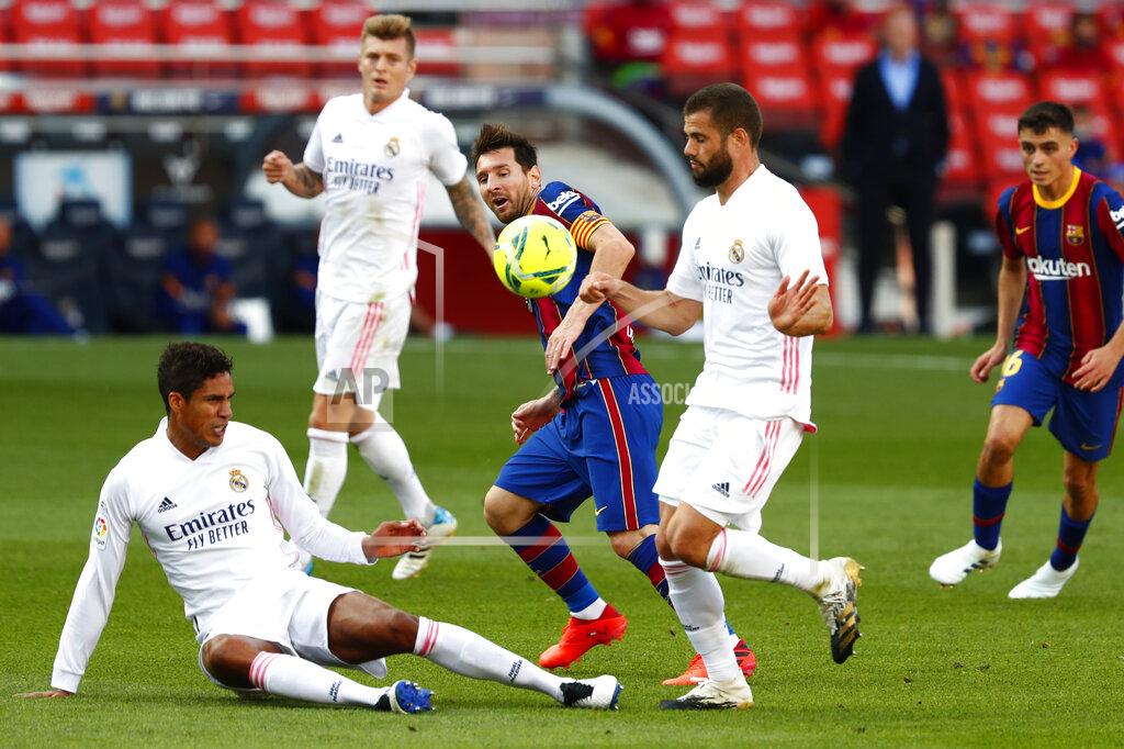 Joan Monfort Barcelona's Lionel Messi fights for the ball against Real Madrid's Raphael Varane and Nacho, right, during the Spanish La Liga soccer match between FC Barcelona and Real Madrid at the Camp Nou stadium in Barcelona, Spain, Saturday, Oct. 24, 2020. (AP Photo/Joan Monfort)