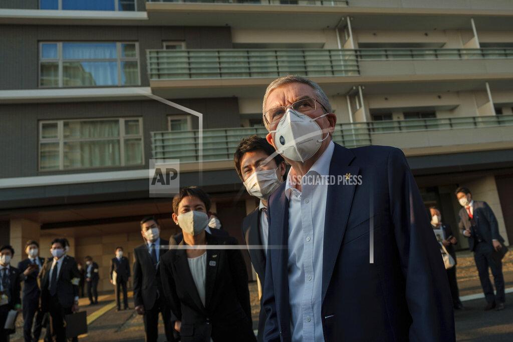 IOC President Thomas Bach wearing a protective mask visits the Olympic and Paralympic Village in Tokyo Tuesday, Nov. 17, 2020. Bach said during this week's trip to Tokyo that he is “encouraging” all Olympic “participants” and fans to be vaccinated - if one becomes available - if they are going to attend next year's Tokyo Olympics. (Nicolas Datiche/Pool Photo via AP)