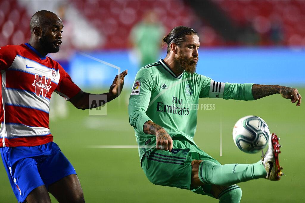 Jose Breton Real Madrid's Sergio Ramos, right, controls the ball with Granada's Dimitri Foulquier during the Spanish La Liga soccer match between Granada and Real Madrid at the Los Carmenes stadium in Granada, Spain, Monday, July 13, 2020. (AP Photo/Jose Breton)