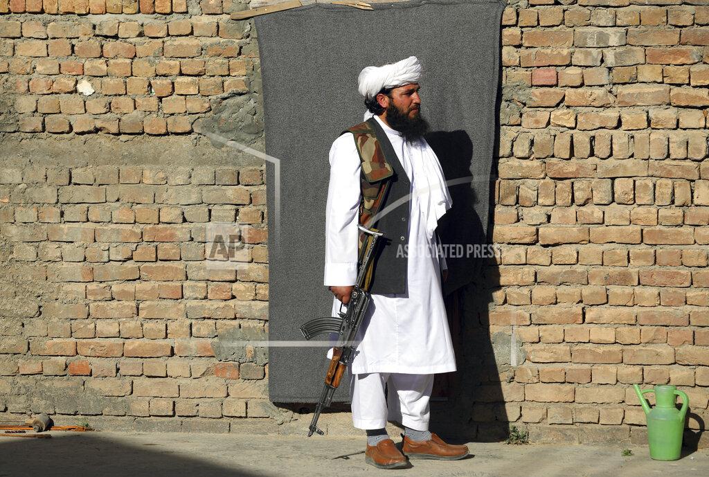 Rahmat Gul Mofti Noman's house guard stand in front of his home near the mosque after a bomb explosion in Shakar Dara district of Kabul, Afghanistan, Friday, May 14, 2021. A bomb ripped through a mosque in northern Kabul during Friday prayers killing 12 worshippers, Afghan police said. (AP Photo/Rahmat Gul)