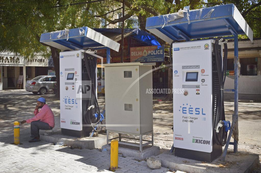 Neha Mehrotra An attendant of a public charging station for electric vehicles sits idle in New Delhi, India, Thursday, April 1, 2021. India has ambitions to expand use of electric vehicles to wean itself from polluting fossil fuels, but EVs are still a rarity on its congested highways. A lack of charging stations and poor quality batteries are discouraging drivers from switching over. (AP Photo/Neha Mehrotra)