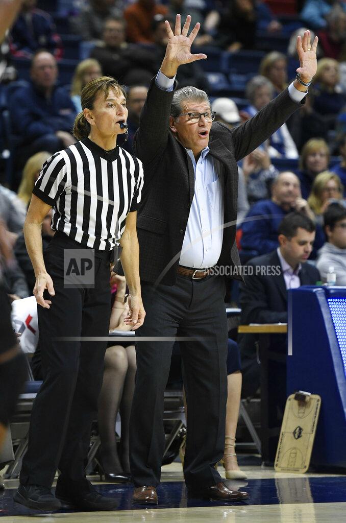 Jessica Hill FILE - Connecticut head coach Geno Auriemma gestures to his team as official Dee Kantner, left, watches play during the second half an NCAA college basketball game against Central Florida, Tuesday, Jan. 9, 2018, in Storrs, Conn. As the NCAA examines various disparities across men’s and women’s sports, pressure is rising to pay referees equally throughout the regular season — and three top conferences told The Associated Press they plan to make changes. (AP Photo/Jessica Hill, File)