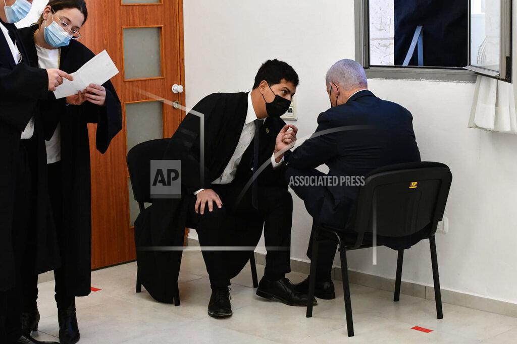 Reuven Castro Israeli Prime Minister Benjamin Netanyahu, right, speaks with his lawyers prior to a hearing at the district court in Jerusalem, Monday, Feb. 8, 2021. Netanyahu appeared in a Jerusalem courtroom Monday to respond formally to corruption charges just weeks before national elections in which he hopes to extend his 12-year rule. (AP Photo/Reuven Castro, Pool)
