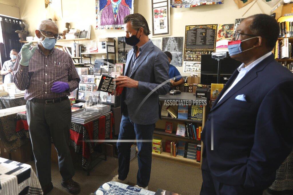 Genaro Molina James Fugate, co-owner of Eso Won Books, speaks with California Gov. Gavin Newsom and Los Angeles Supervisor Mark Ridley-Thomas while touring businesses in Leimert Park in Los Angeles on Wednesday, June 3, 2020. (Genaro Molina/Los Angeles Times via AP, Pool)