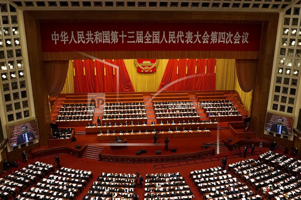 Andy Wong With screens showing Chinese President Xi Jinping, delegates attend the opening session of China's National People's Congress (NPC) at the Great Hall of the People in Beijing on Friday, March 5, 2021. The U.S. sanctioned an additional 24 Chinese and Hong Kong officials over Beijing's ongoing crackdown on political freedoms in the semi-autonomous city, including a decision to overhaul Hong Kong's electoral system. (AP Photo/Andy Wong)